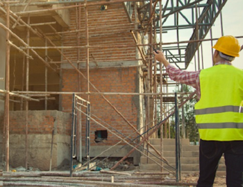 Bouwlocatie met een man in geel veiligheidsvest